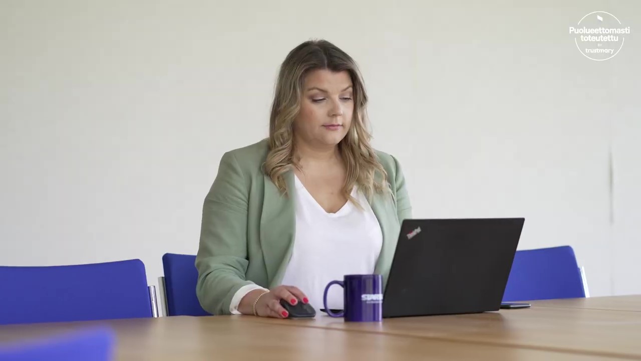 Nainen työskentelee kannettavalla tietokoneella kokoushuoneessa ja käyttää ERP-järjestelmää.